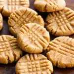 Keto Peanut Butter Cookies – Easy 3-Ingredient Low-Carb Recipe 5 A group of keto peanut butter cookies on a baking tray with visible texture