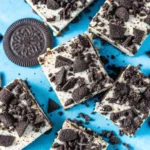 Cookies and Cream Bar Recipe Everyone Loves (Soft, Chewy & Loaded) 5 Oreo cheesecake squares on a bright blue background