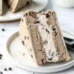 Close-up of a slice of cookie dough ice cream cake on a white plate