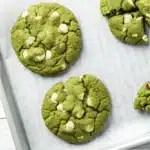 Freshly baked matcha white chocolate cookies on a tray with parchment paper