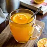 Apple cider vinegar detox drink in a glass mug with fresh orange slice