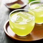 Refreshing cold brew green tea with ice cubes in a glass cup