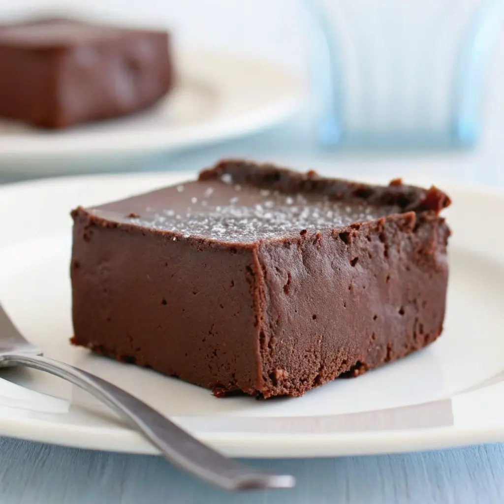 Cottage Cheese Fudge Recipe: Easy, High-Protein, Dessert-Like Treat 4 Single piece of chocolate cottage cheese fudge on a plate with sea salt topping