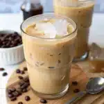 Refreshing glass of Vietnamese iced coffee with ice cubes on a wooden board